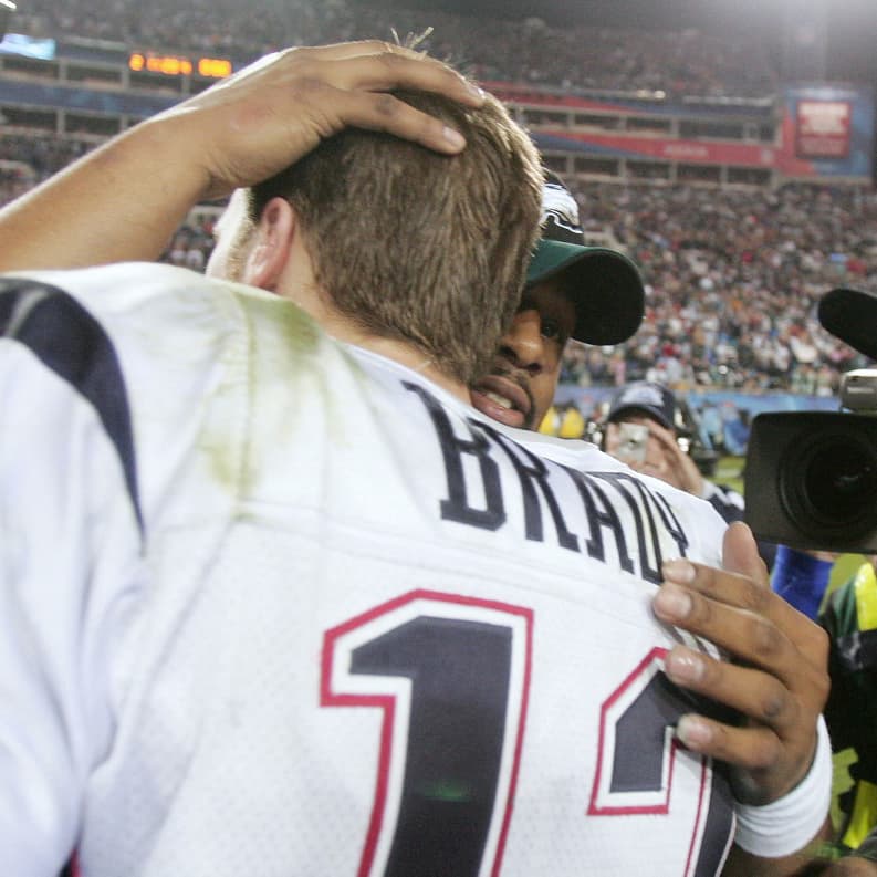 JACKSONVILLE, FLORIDA - FEBRUARY 06:  Quarterbacks Tom Brady #12 of the New England Patriots and Donovan McNabb #5 of the Philadelphia Eagles hug after Super Bowl XXXIX at Alltel Stadium on February 6, 2005 in Jacksonville, Florida.  The Patriots defeated the Eagles 24-21.  (Photo by Jed Jacobsohn/Getty Images) *** Local Caption *** Donovan McNabb;Tom Brady (Photo by Jed Jacobsohn / Getty Images North America / Getty Images via AFP)