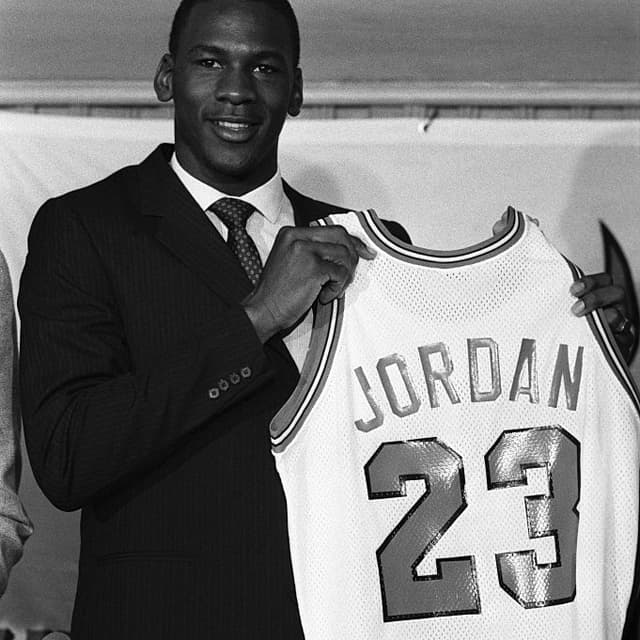 (Original Caption) Former North Carolina star, College Player of the Year and star of the US Olympic gold medal winning basketball team, Michael Jordan holds up his Chicago Bulls jersey 9/12 at a news conference. Bulls General Manager Rod Thorn announced they have signed Jordan, their first round draft pick, to a multi-million dollar contract which is expected to make him the third highest paid in NBA history.