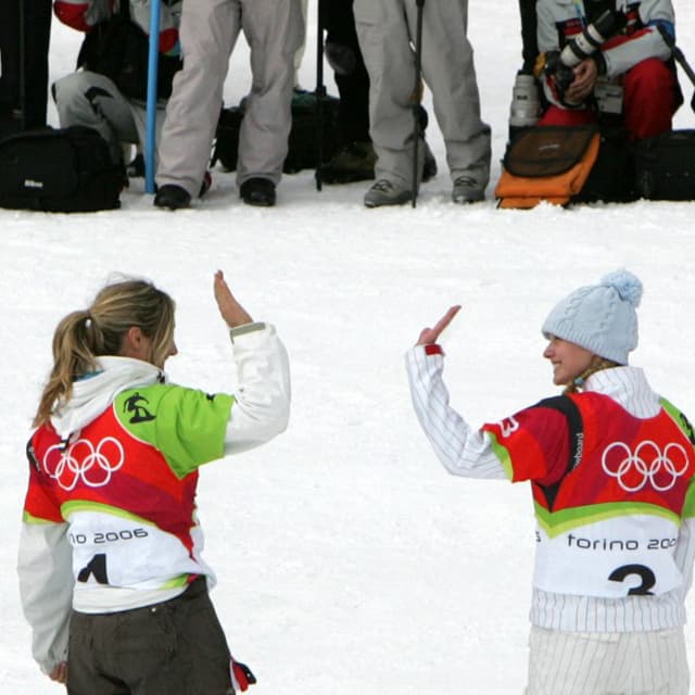 Switzerland's Tanja Frieden (L) celebrates on the podium with US Lindsey Jacobellis after winning the Ladies' Snowboard Cross final at the Turin 2006 Winter Olympics 17 February 2006 in Bardonecchia, Italy. Switzerland's Tanja Frieden won ahead of US Lindsey Jacobellis and Canada's Dominique Maltais. The Turin Winter Olympics officially opened 10 February setting the ball rolling on a 17-day festival of snow and ice sports. AFP PHOTO JOE KLAMAR (Photo by JOE KLAMAR / AFP)