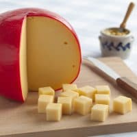 Edam cheese and cubes on a cutting board
