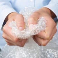 Female hands popping the bubbles of bubble wrap. Stress relief, anger management