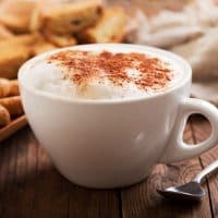 Cup of cappuccino coffee on wooden table