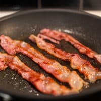 Delicious Bacon being cooked, fried.