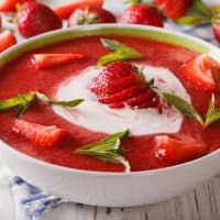 Sweet cold strawberry soup with mint and sour cream in a bowl close-up. horizontal