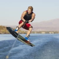 A young wake boarder in midair while wakeboarding on lake