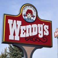 "Clio, Michigan, USA - March 7, 2012: The Wendy's location in Clio, Michigan. Founded in 1969 by Dave Thomas, Wendy's is a chain of fast food restaurants with over 6,600 locations in the US and abroad."