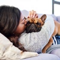Shot of a young woman relaxing with her dog at home