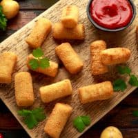 Homemade Potato Croquettes with dipping sauce on wooden board.