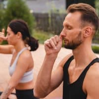 Close up photo of two caucasian yogi breathing deeply with one nostril during yoga class