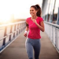 Young woman jogging outdoors on bridge. Concept of healthy lifestyle.