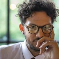 Close-up shot of a male wedding guest sitting looking at the camera, he is confident and having a fun time at a wedding party in Cumbria, England.