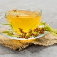 Glass cup of tea from linden flowers on a gray background. The concept of healthy teas