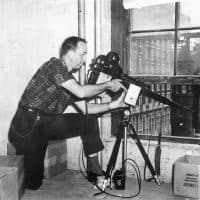 A man points the alleged murder weapon, a 6.5 mm Mannlicher-Carcano owned by Lee Harvey Oswald, in a reenactment of President Kennedy's assassination. This image, taken on September 27, 1964, was presented with the Warren Commission's report on Kennedy's