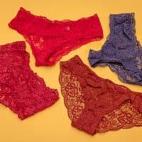 Colorful lace material female knickers underwear isolated on yellow background