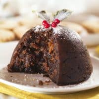 Christmas pudding with holly and mince pies in background and white and gold table colours. See also:
