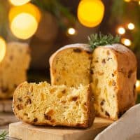 Traditional Italian Christmas cake Panettone on a rustic table with festive holiday decorations