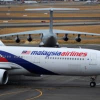 PERTH, AUSTRALIA - MARCH 25:  A Malaysia Airlines plane prepares to go out onto the runway and passes by a stationary Chinese Ilyushin 76 aircraft (top) at Perth International Airport on March 25, 2014 in Perth Australia.  The Australian Maritime Safety Authority has suspended the air and sea search for the missing Malaysian Airlines flight MH370 due to poor weather conditions in the search area. Search operations are expected to resume tomorrow.  (Photo by Greg Wood - Pool/Getty Images)