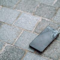 Broken stealing black phone with cracks on the floor. Need to repair