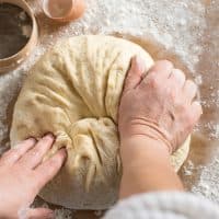 Woman kneading dough in kitchen