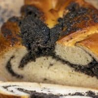 Fresh bun with poppy seed filling on the table, sweet flour dessert with sweet filling with poppy seeds