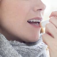 Woman applying lip balm.