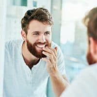 Cropped shot of a handsome young man looking at his teeth in the bathroom mirror