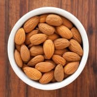 Top view of white bowl full of almonds