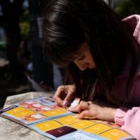 BUENOS AIRES, ARGENTINA - SEPTEMBER 24: A sticker collector places her new exchanged stickers on her Panini World Cup album at Centenario Park where people meet to exchange their spares  on September 24, 2022 in Buenos Aires, Argentina. Amid Panini World Cup sticker shortage, the Argentine government held meetings with representatives from the federation of kiosks and Panini manufacturer to solve the situation.  (Photo by Tomas Cuesta/Getty Images)