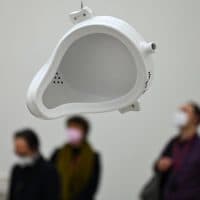 01 April 2022, Hessen, Frankfurt/Main: Participants in a press conference stand behind the exhibit "Porcelain Urinal (1917/1964)" by French artist Marcel Duchamp (1887-1968) at Frankfurt's Museum of Modern Art (MMK). The exhibition "Marcel Duchamp" will present almost 700 works by the artist from all creative phases from 1902 to 1968 from April 1 to October 3, 2022. Photo: Arne Dedert/dpa (Photo by ARNE DEDERT / DPA / dpa Picture-Alliance via AFP)