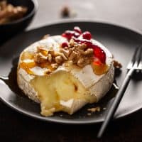Closeup of tasty baked camembert with nuts and cranberries.