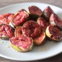 Roasted Fig halves served with a drizzle of honey. Roasting is done using an air fryer. Shot on rustic wooden background