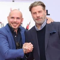 HOLLYWOOD, CALIFORNIA - DECEMBER 14: recording Artist (L) and Actor John Travolta (R) attend the Hand and Footprint ceremony for Pitbull at TCL Chinese Theatre on December 14, 2018 in Hollywood, California. (Photo by Paul Archuleta/FilmMagic)