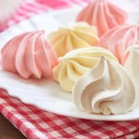 Fresh delicious colored meringue cookies served on white plate