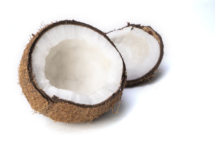 fresh coconut broken in half isolated on white background