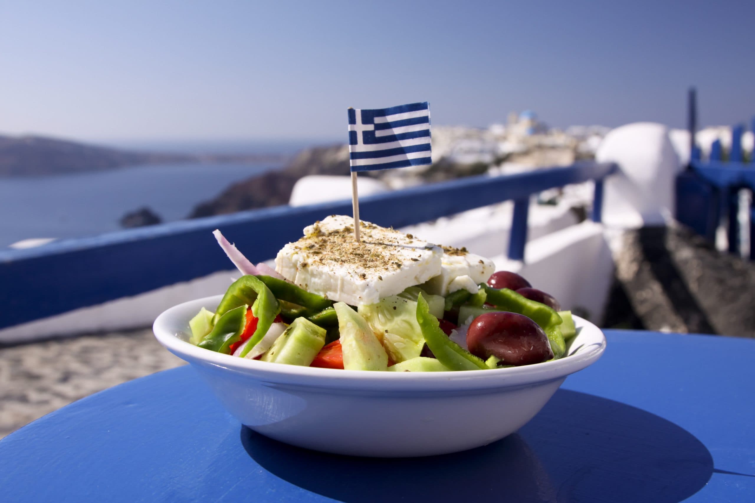 A perfect Greek salad, incorporating olives, green peppers and feta cheese, topped with a Greek flag, in Oia, Santorini