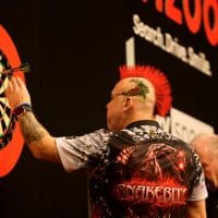 30 March 2023, Berlin: Darts: Premiere League, 9. league day in the Mercedes-Benz Arena; Price (Wales) v Wright (Scotland). Peter Wright removes the darts after a 180 throw. Photo: Jean-Marc Wiesner/dpa (Photo by Jean-Marc Wiesner/picture alliance via Getty Images)