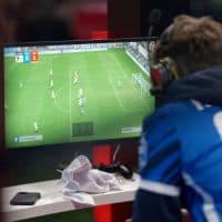 25 March 2023, North Rhine-Westphalia, Cologne: Players sit in front of a screen on the first day of the Virtual Bundesliga Club Championship final in FIFA 23. Photo: Henning Kaiser/dpa (Photo by Henning Kaiser/picture alliance via Getty Images)
