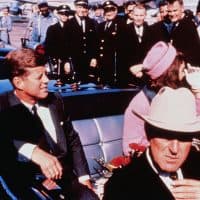 (Original Caption) Texas Governor John Connally adjusts his tie (foreground) as US President John F Kennedy (left) &amp; First Lady Jacqueline Kennedy (in pink) settled in rear seats, prepared for motorcade into city from airport, Nov. 22. After a few speaking stops, the President was assassinated in the same car.