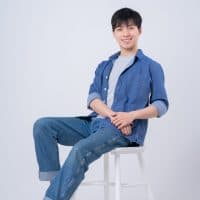 Young Asian man sitting on white background