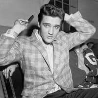 (Original Caption) Elvis Presley runs a comb through his famous tresses at the Draftee Receiving Depot here on March 24th. The songster is scheduled for a trip to the G. I. barber on March 25th, where the key to his locks will probably be found.