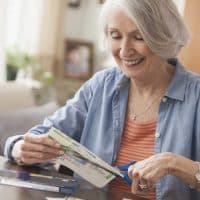 Senior Caucasian woman clipping coupons
