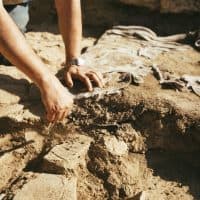 Close up of a man hand using a brush to Dust Pottery at Archaeological Site