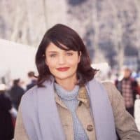 circa 1995:  A headshot of Dutch-born model Helena Christensen walking outdoors and smiling (possibly at Bryant Park in New York City during New York Fashion Week). Christensen wears a tweed coat with a periwinkle scarf and chenille turtleneck sweater.  (Photo by Mark Rylewski/Hulton Archive/Getty Images)