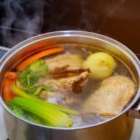 Chicken soup broth ingredients carrots chicken with vegetables soup in a pot