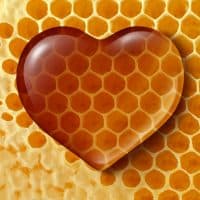 Healthy food love concept as liquid honey shaped as a heart on a honeycomb or honey comb background created by bees as a healthy lifestyle sweetener symbol of fresh natural organic nutrition from nature.