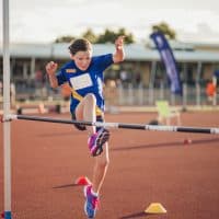 Little girl is training for the high jump at athletics club.