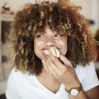 Black woman biting sandwich